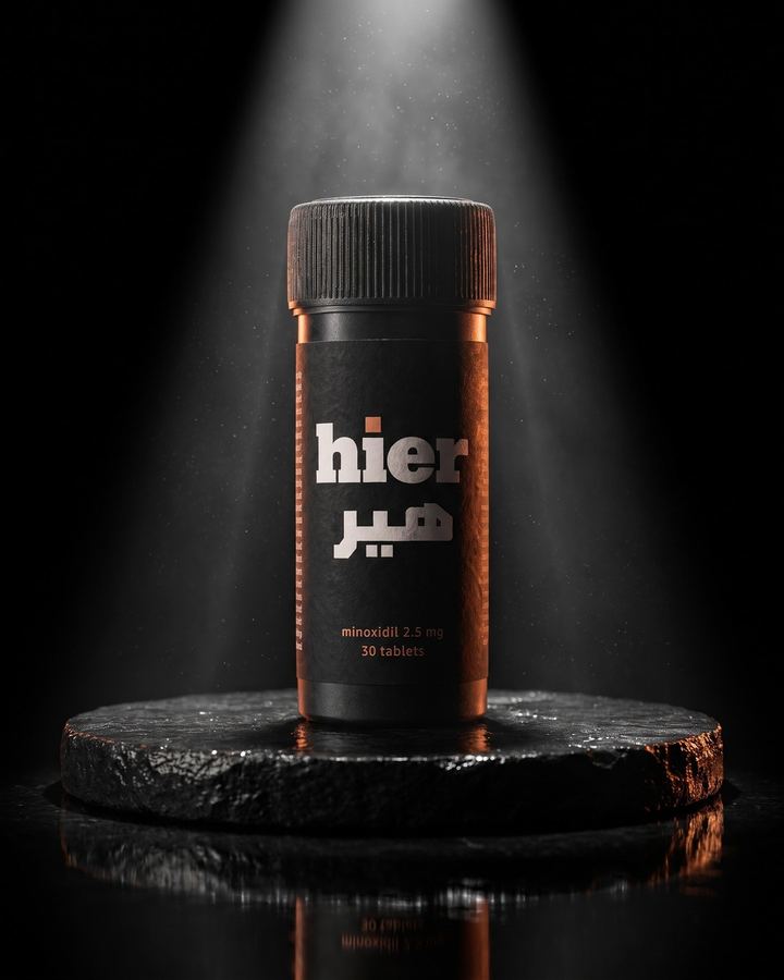 A single hier bottle on a stone pedestal under a spotlight